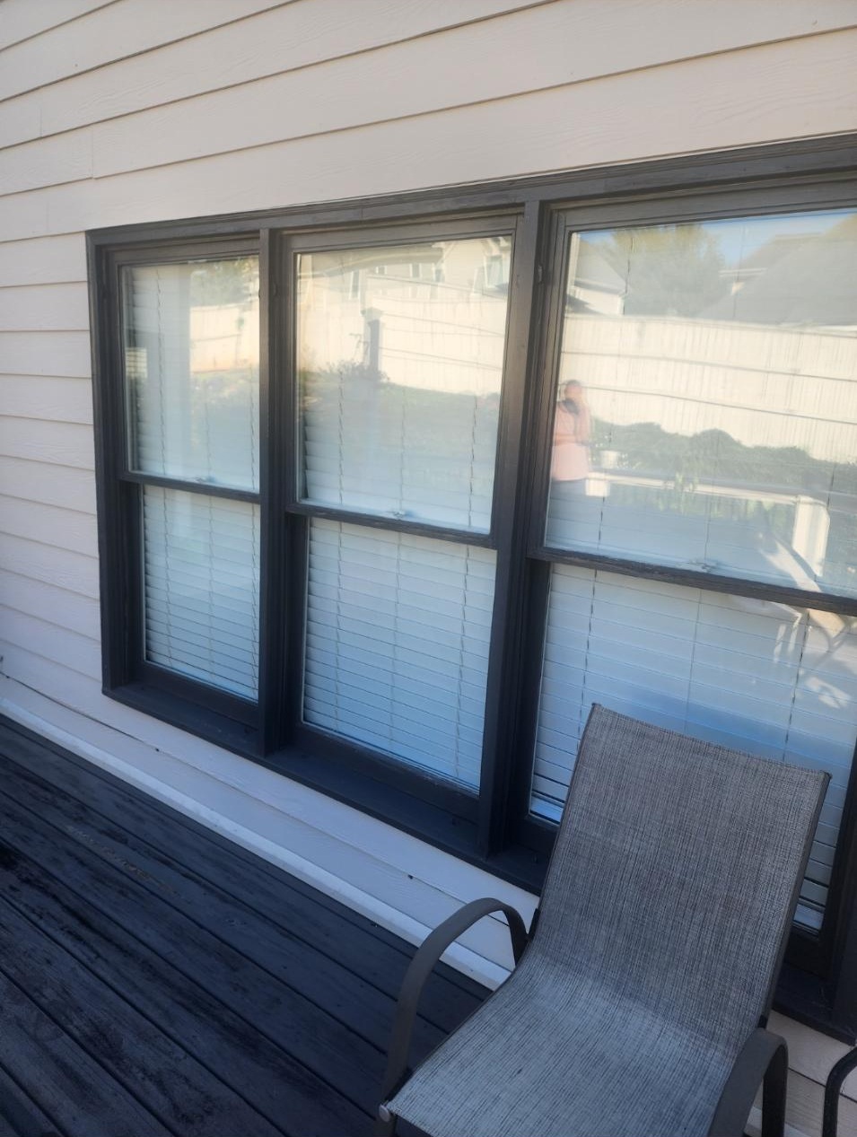 Finished black-framed replacement windows beside a deck